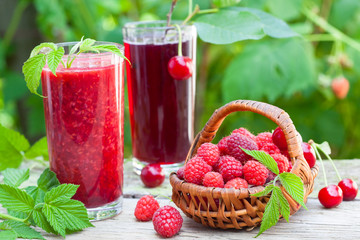 Raspberry and sour cherry juice on rustic table