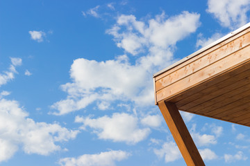Wooden corner against the blue sky