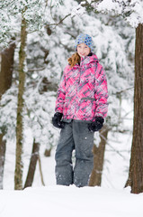 pretty teen girl playing out in a beautiful snowy forest