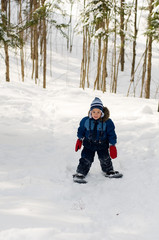 Fototapeta na wymiar four year old boy out snowshoeing in a winter forest