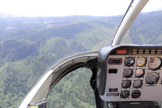 Helicopter cockpit view of the hills and forest.