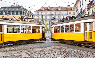 Fototapeta na wymiar Two famous vintage yellow tramways in the city center if Lisbon.