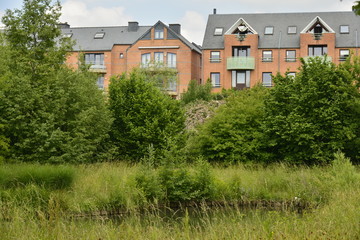 Lotissement moderne émergeant de la végétation à Louvain-la-Neuve