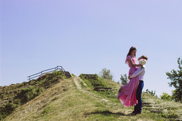 Newlyweds tseltsyutsya in the park. Bride is holding a bouquet of beautiful flowers