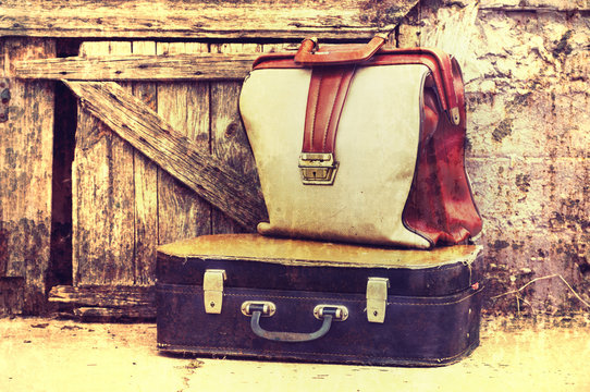 Two old retro of a suitcase on wooden grunge a background.
