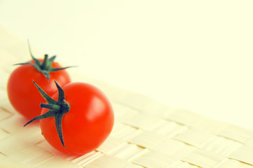 Cherry tomatoes on a wattled napkin on a light background. Tomatoes