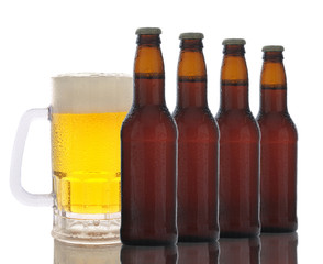 A frosty mug of beer behind a row of brown beer bottles. Horizontal format over white with...