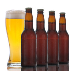 Four Brown Beer Bottles and Full Glass