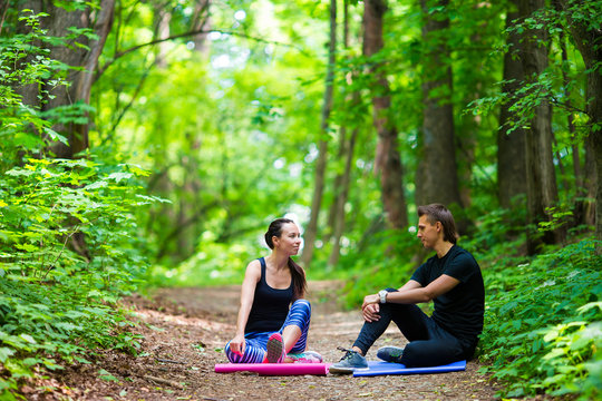 Young Active Couple Making Stretching Yoga Exercises Outside In