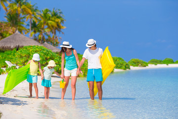 Happy family on white beach with air mattresses 