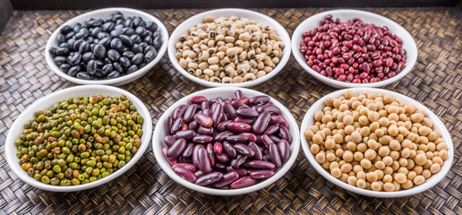 Beans variety in white bowl on in wicker tray