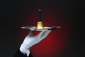 Hand Holding a Service Bell on Tray
