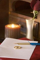 le fedi nuziali poste sopra il foglio di carta per ispirare la scrittura della lettera d'amore
