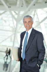 Fototapeta premium Middle aged Businessman in Lobby with Folder