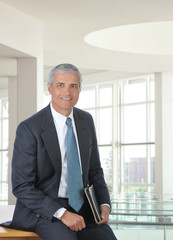 Fototapeta premium Middle Aged Businessman Sitting on Desk