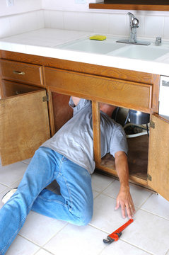 Man Under Sink Reaching for Wrench