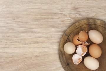 Whole eggs and shells lying on a wooden table. Preparing fried omelets.
