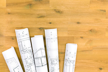 rolls of architectural blueprints on wooden table