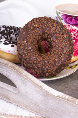 donuts and cup of coffee on wood background