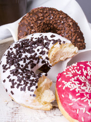 bitten donuts with icing on a white napkin