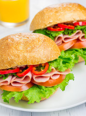 Healthy ham sandwiches on the plate with orange juice