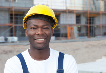 Sympathischer afrikanischer Bauarbeiter auf der Baustelle