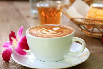 Vintage latte art coffee and pink orchid