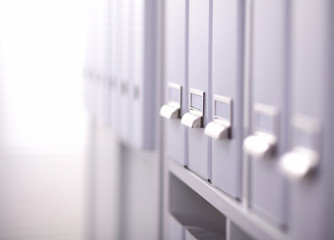 File folders, standing on shelves in the background