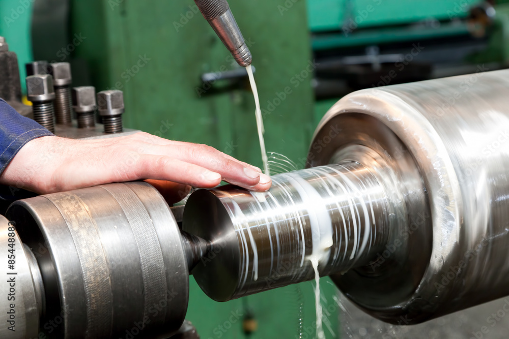 Wall mural worker measuring on industrial turning machine. industry