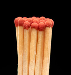 Group of red wooden matches isolated on black background