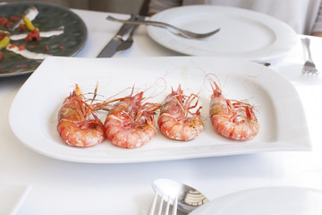 four delicious big prawns on white tray