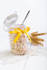 The oat flakes in glass jar and wheat.