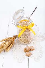 The oat flakes in glass jar and wheat.