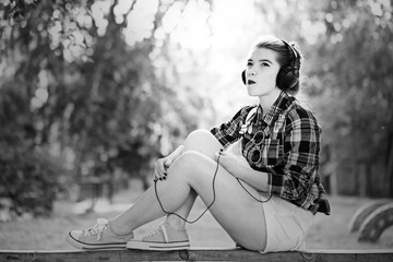 Hipster girl listening to music on headphones.