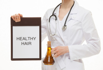 Doctor holding a clipboard with text "Healthy hair" and vessel w