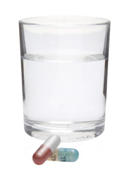 Tabletten mit einem Glas Wasser