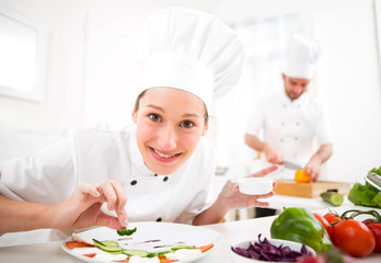 Young attractive professional chef cooking in his kitchen