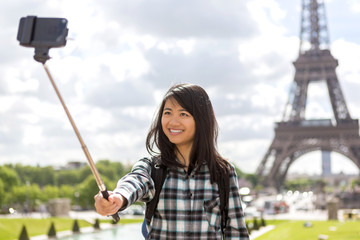 Young attractive asian tourist in Paris taking selfie