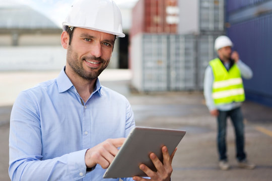 Young Attractive engineer using tablet on the dock