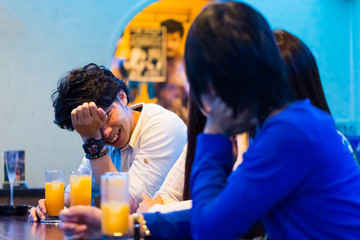 カウンターでお酒を飲む若者   © Taku