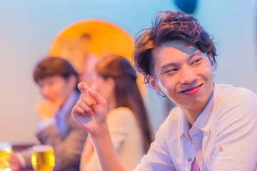 カウンターでお酒を飲む若者   © Taku
