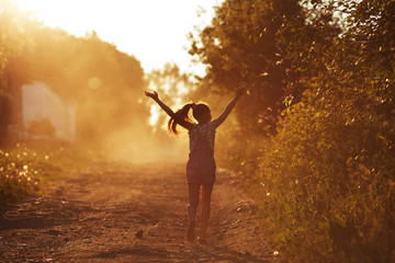 Happy girl running on a dusty road