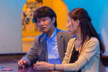 カウンターでお酒を飲むカップル   © Taku