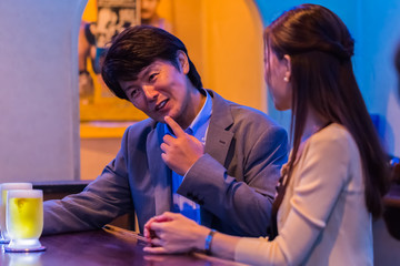 カウンターでお酒を飲むカップル   © Taku