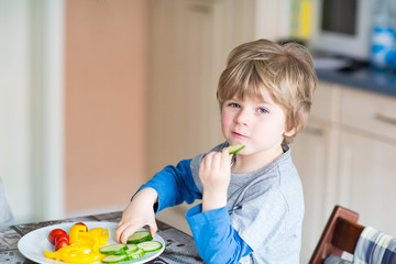 kid boy eating healthy food in kindergarten or at home