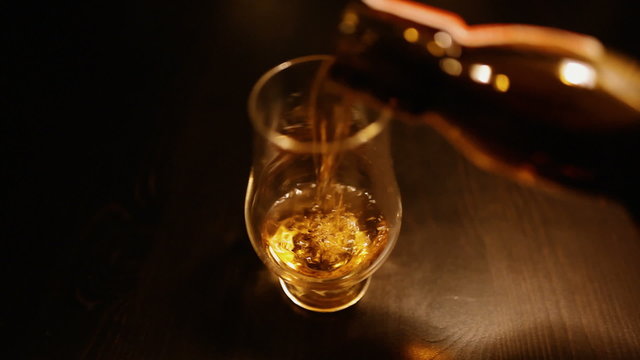 Pouring a glass of single malt Scotch whisky from a bottle (hd, 1080p, 1920x1080) beautiful soft focus shot