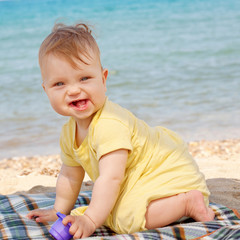 Fototapeta na wymiar Smiling baby playing on beach