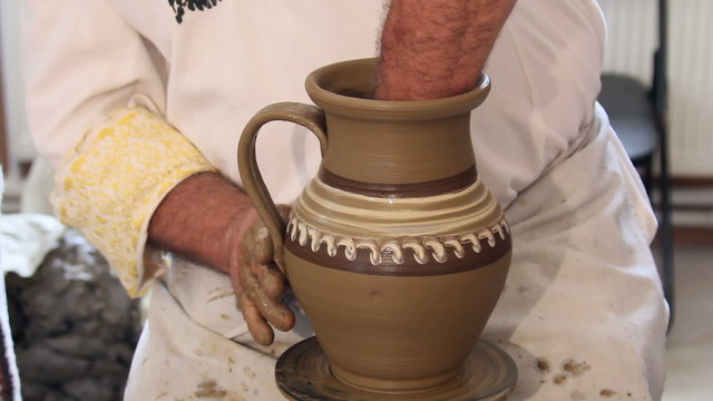 Craftsman shapes pottery on an classic potter's kick wheel