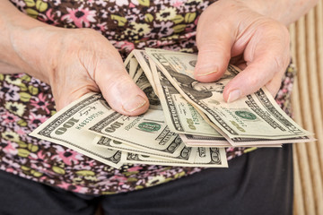 close up hands of a senior woman holding money