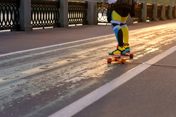 skateboarder on the board moves on a running track during sunset. Beautiful sun glare and soft...